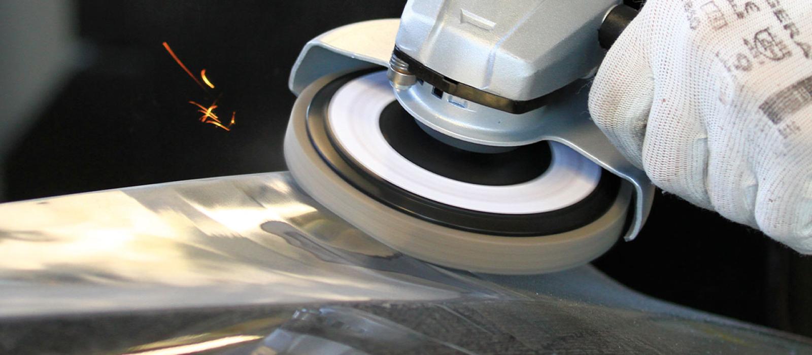 Bild på person som bearbetar en yta med hjälp av unitized sliprondell