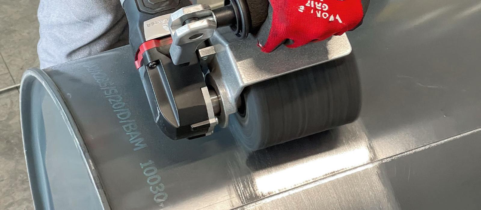 Bild på person som tar bort färg från metall med grovrengörare