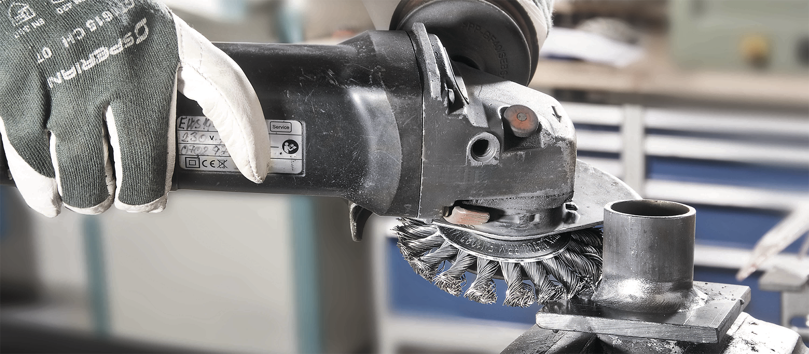 Bild på person som bearbetar en svetsfog med stålborste