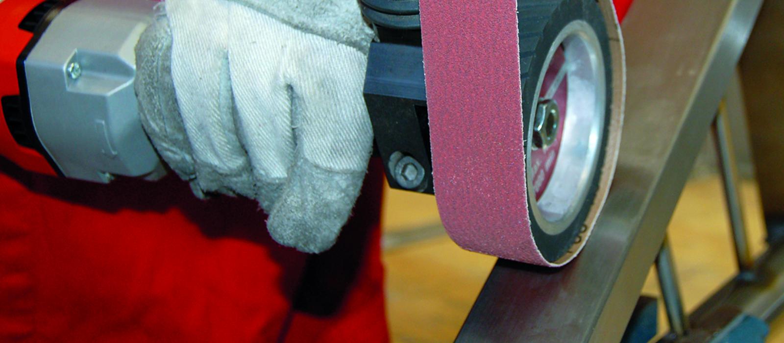 Bild på person som slipar med slipduksband