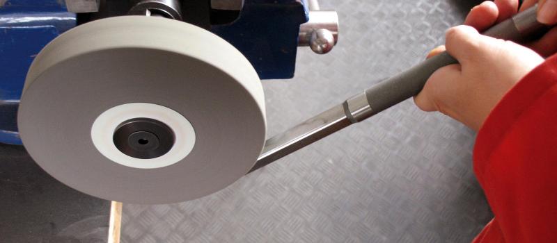 Bild på person som bearbetar en detalj med hjälp av en lättgradningsskiva